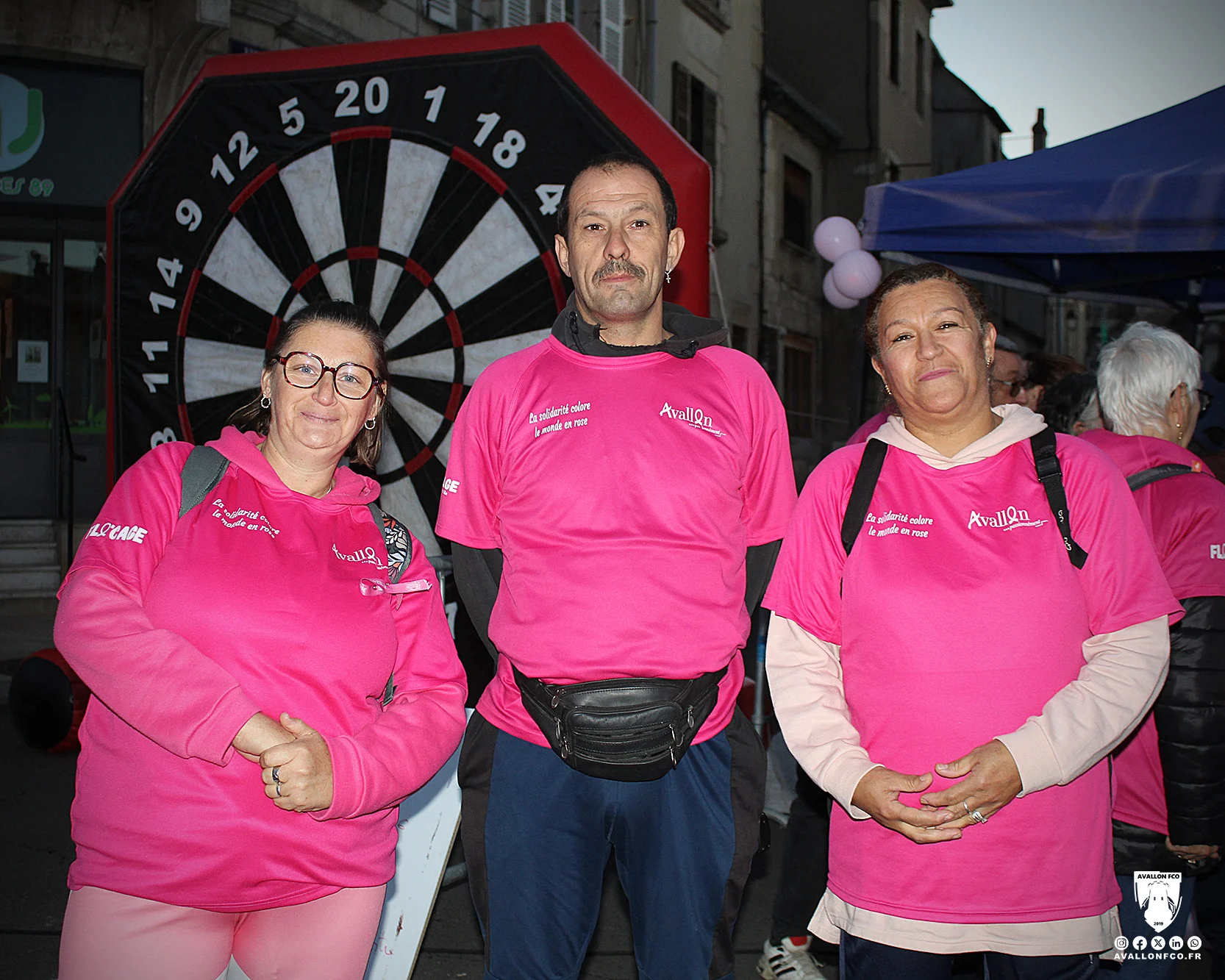 Des participants en rose devant la cible géante du stand AFCO