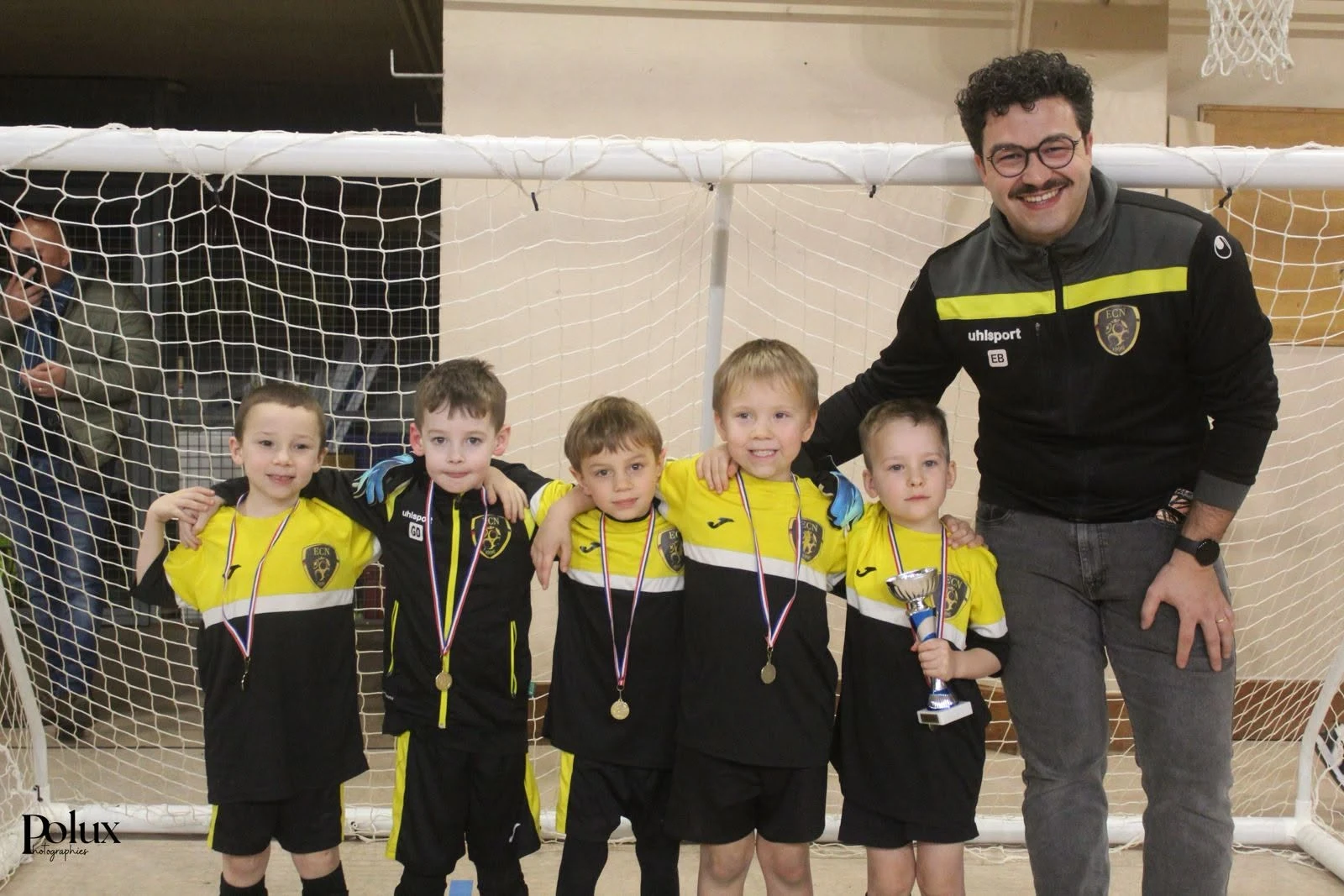 De jeunes participants et leur éducateur, médailles autour du cou, lors d’une précédente édition du tournoi