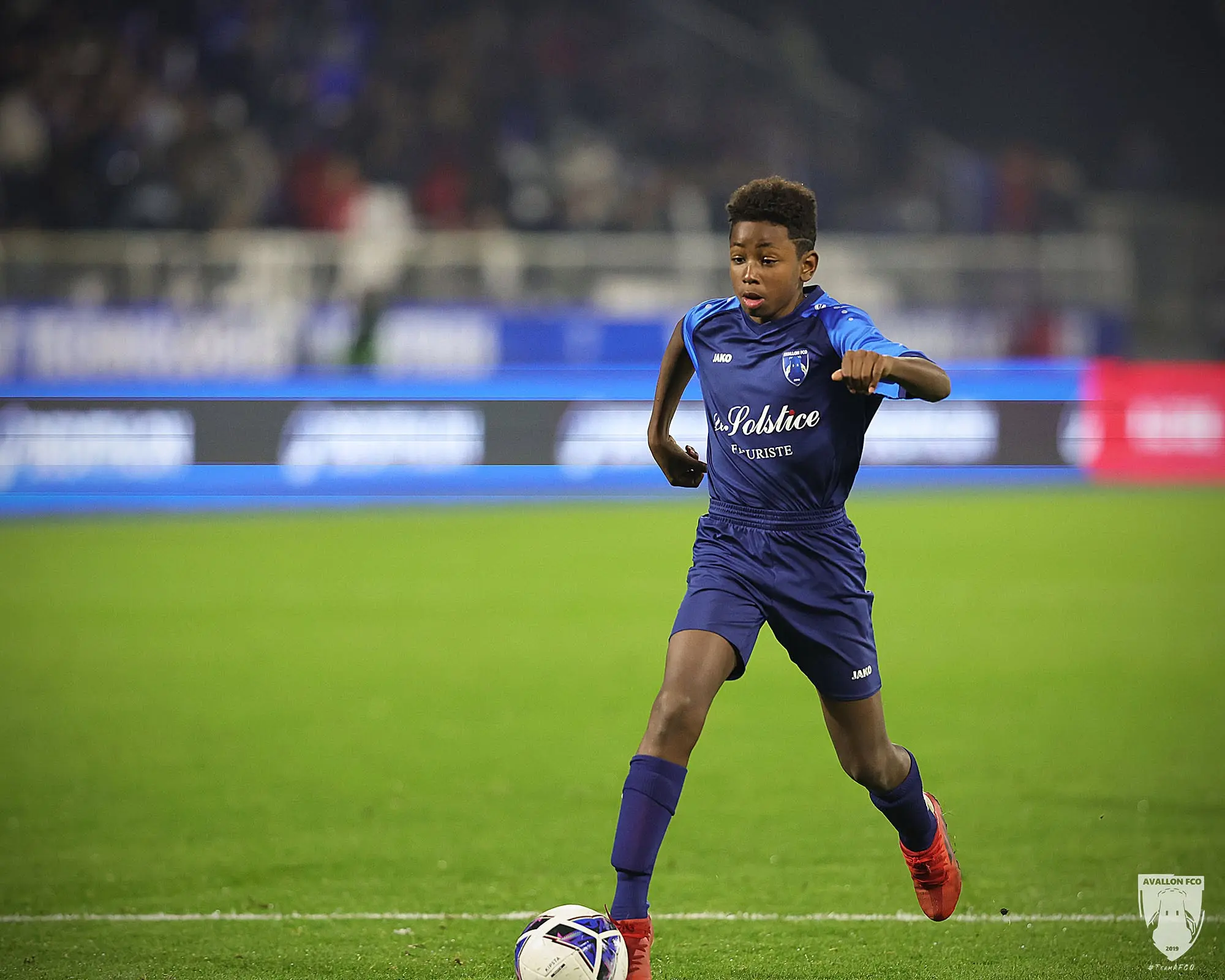 Un joueur U13 de l’AFCO progresse avec le ballon