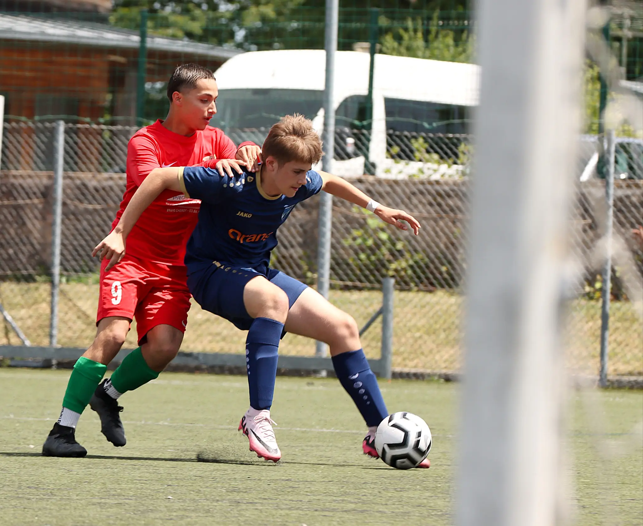Un joueur U15 de l’AFCO protège son ballon face à un adversaire